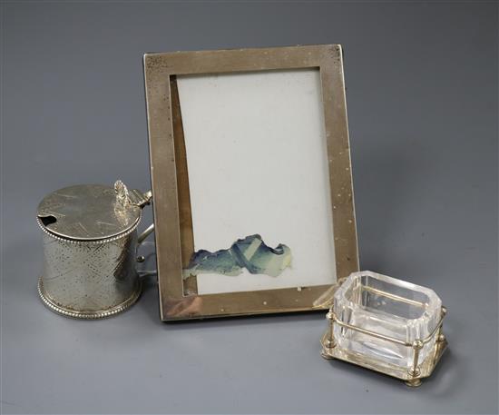 A Victorian silver mustard pot, London, 1862, a George V silver mounted photograph frame and a Hukin & Heath plated salt.